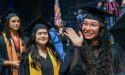 Hispanic female graduates in caps and gowns smile and wave during a graduation ceremony. The Tu Camino Scholarship supports Hispanic adults pursuing career growth through education. Credit: Lone Star College System.